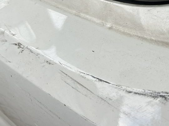 Schadenbild aus einer abgerechneten Akte: Schürfspuren und Verformung an der hinteren Seitenwand eines Kombis